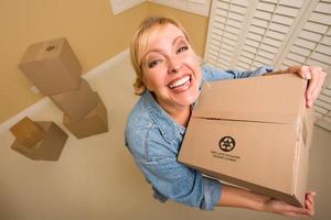 Excited Woman Holding Moving Boxes in Empty Room photo