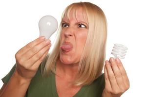 Funny Woman Holding Energy Saving and Regular Light Bulbs photo