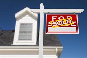 Right Facing Sold For Sale Real Estate Sign In Front of House and Deep Blue Sky. photo