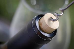 Close-up of Corkscrew Twisted Into Cork of Wine Bottle. photo