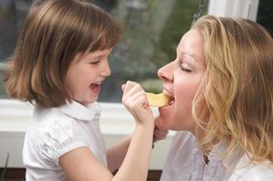hija alimentando a mamá con una manzana foto