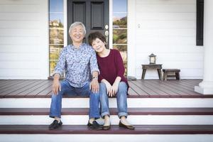 Senior Chinese Couple Sitting on Front Steps of Their House photo