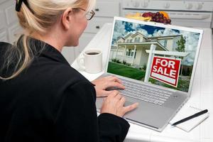 Woman In Kitchen Using Laptop for Real Estate photo