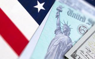 United States IRS Check, Envelope and Money Resting on American Flag photo