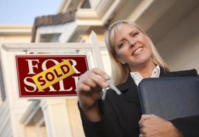 Real Estate Agent with Keys in Front of Sold Sign and House photo