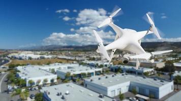 Unmanned Aircraft System Quadcopter Drone In The Air Over Commercial Buildings. photo