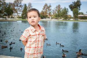 joven chino y caucásico divirtiéndose en el parque y estanque de patos. foto