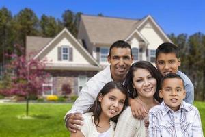 familia hispana frente a una hermosa casa foto