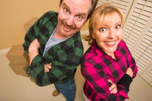 Proud Goofy Couple and Moving Boxes in Empty Room photo