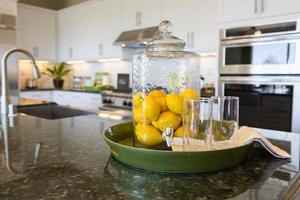 resumen del mostrador de la cocina interior con jarra llena de limón y vasos para beber foto
