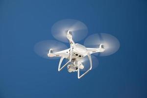 Drone Quadcopter From Below Against A Blue Sky photo