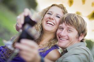 una pareja atractiva disfrutando de una copa de vino en el parque foto