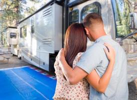 pareja militar mirando una hermosa rv en el campamento. foto