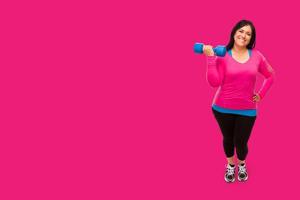 Middle Aged Hispanic Woman In Workout Clothes Holding Dumbbell Against A Bright Magenta Pink Background photo