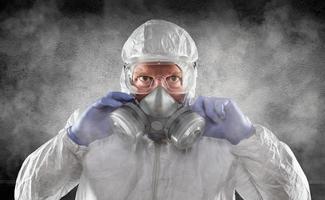 Man Wearing Hazmat Suit, Goggles and Gas Mask Is Smokey Dark Room photo