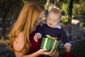 hermosa joven madre y bebé con regalo de navidad foto