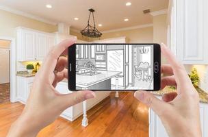 Hands Holding Smart Phone Displaying Drawing of Kitchen Photo Behind