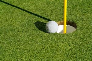 Close-up of Golf Course Green, Flag Pin and Ball. photo