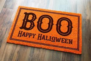 Boo, Happy Halloween Orange Welcome Mat On Wood Floor Background photo