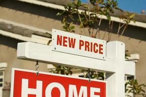 Nuevo signo de bienes raíces de precio y nuevo hogar. foto