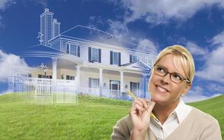 Smiling Woman Holding Pencil Looking to Ghosted House Drawing Behind photo