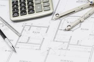 Pencil, Ruler, Compass and Calculator Resting on House Plans photo
