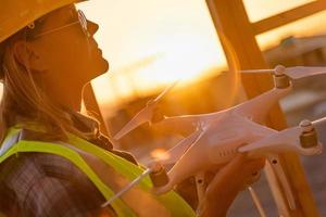 Female Unmanned Aircraft System Quadcopter Drone Pilot Holding Drone at Construction Site photo