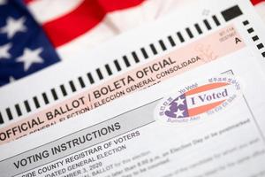Official Ballot and Voting Instructions with I Voted Sticker Laying on American Flag photo