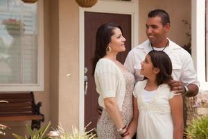 pequeña familia hispana frente a su casa foto