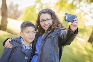 Brother and Sister Taking Cell Phone Picture of Themselves photo