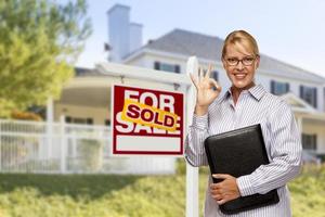 Real Estate Agent in Front of Sold Sign and House photo