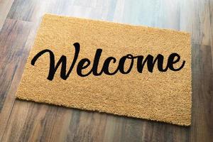 Tan Welcome Mat On Wood Floor Background. photo