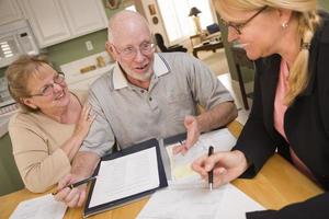 Senior Adult Couple Going Over Papers in Their Home with Agent photo