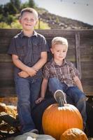 Two Boys at the Pumpkin Patch Against Antique Wood Wagon photo