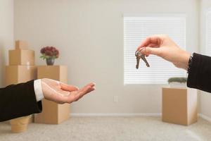 Handing Over House Keys In Room with Packed Moving Boxes photo