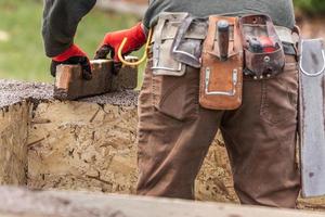 Construction Worker Leveling Wet Cement Into Wood Framing photo