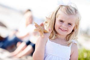 adorable niña rubia con estrellas de mar foto