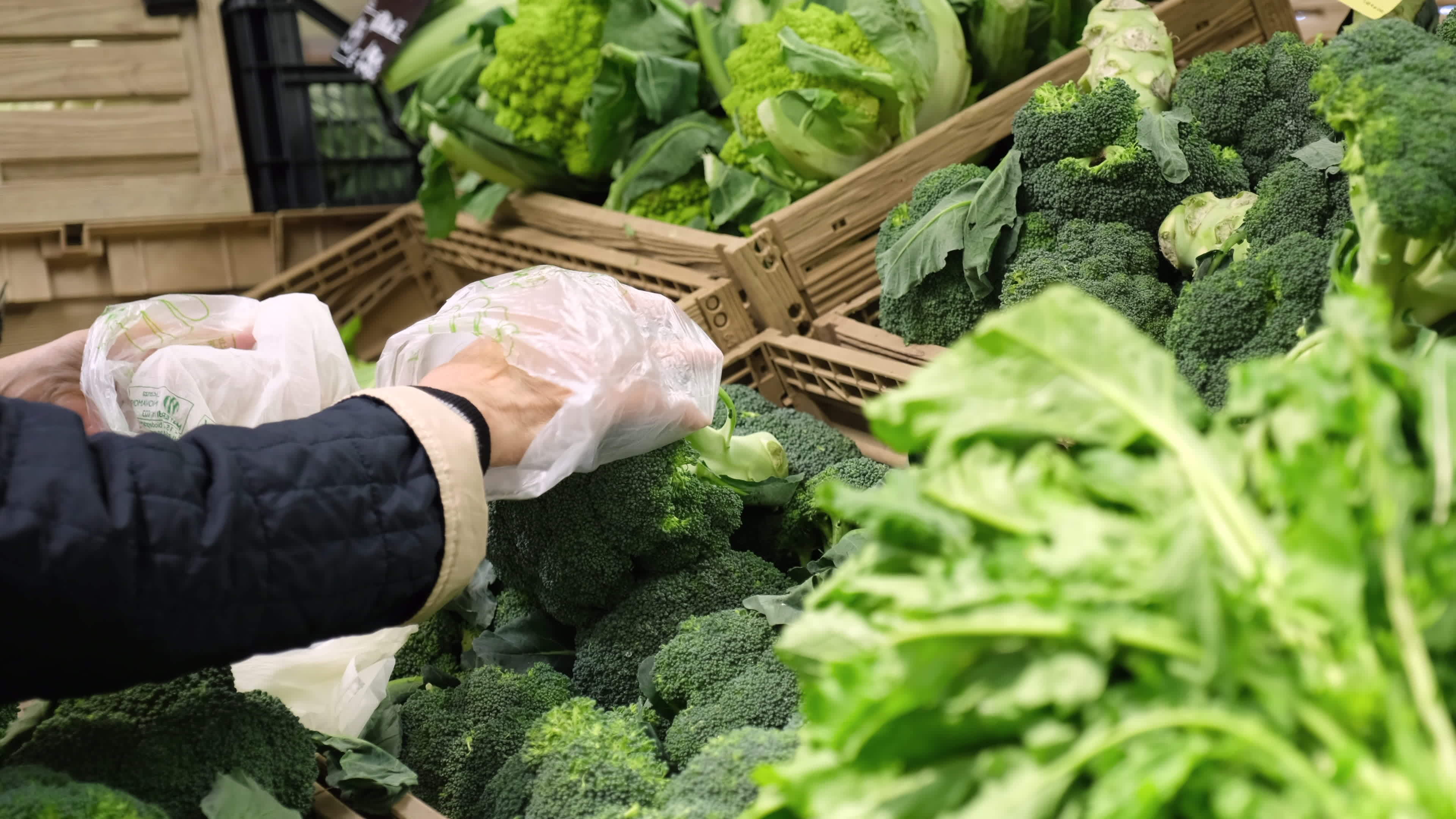 Picking broccoli cauliflower vegetables at super market grocery store