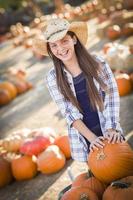 Preteen Girl Playing with a Wheelbarrow at the Pumpkin Patch photo