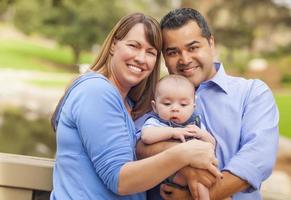 Happy Mixed Race Family Posing for A Portrait Outside photo