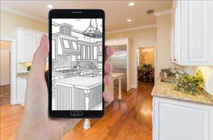 Hand Holding Smart Phone Displaying Drawing of Kitchen Photo Behind