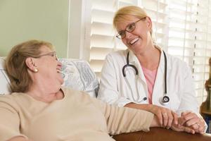 Doctor or Nurse Talking to Sitting Senior Woman photo