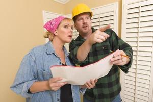 Contractor in Hard Hat Discussing Plans with Woman photo