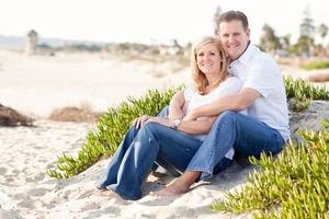 atractiva pareja caucásica relajándose en la playa foto