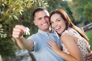 feliz pareja emocionada con nuevas llaves de casa foto