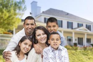 familia hispana frente a una hermosa casa foto