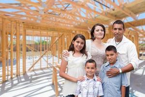 joven familia hispana en el sitio dentro del nuevo marco de construcción de viviendas. foto