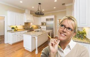 Daydreaming Woman with Pencil Inside Beautiful Custom Kitchen photo