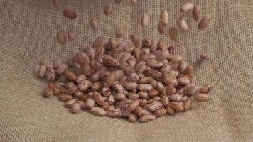 Pile of red dry beans legumes falling on jute at slow motion, organic agriculture, healthy protein source video