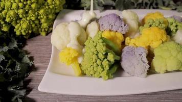 Bechamel auf bunten Brokkoli-Blumenkohlteller gießen. gesundes frisches vegetarisches veganes essen. Bio-Kochen, Ernährung. Slider erschossen.